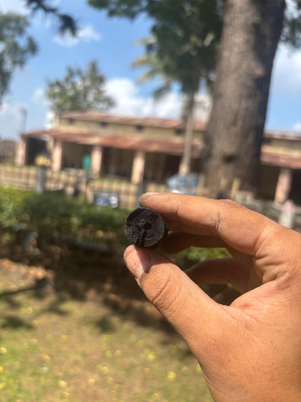 A close view of a single biochar piece held at the project site